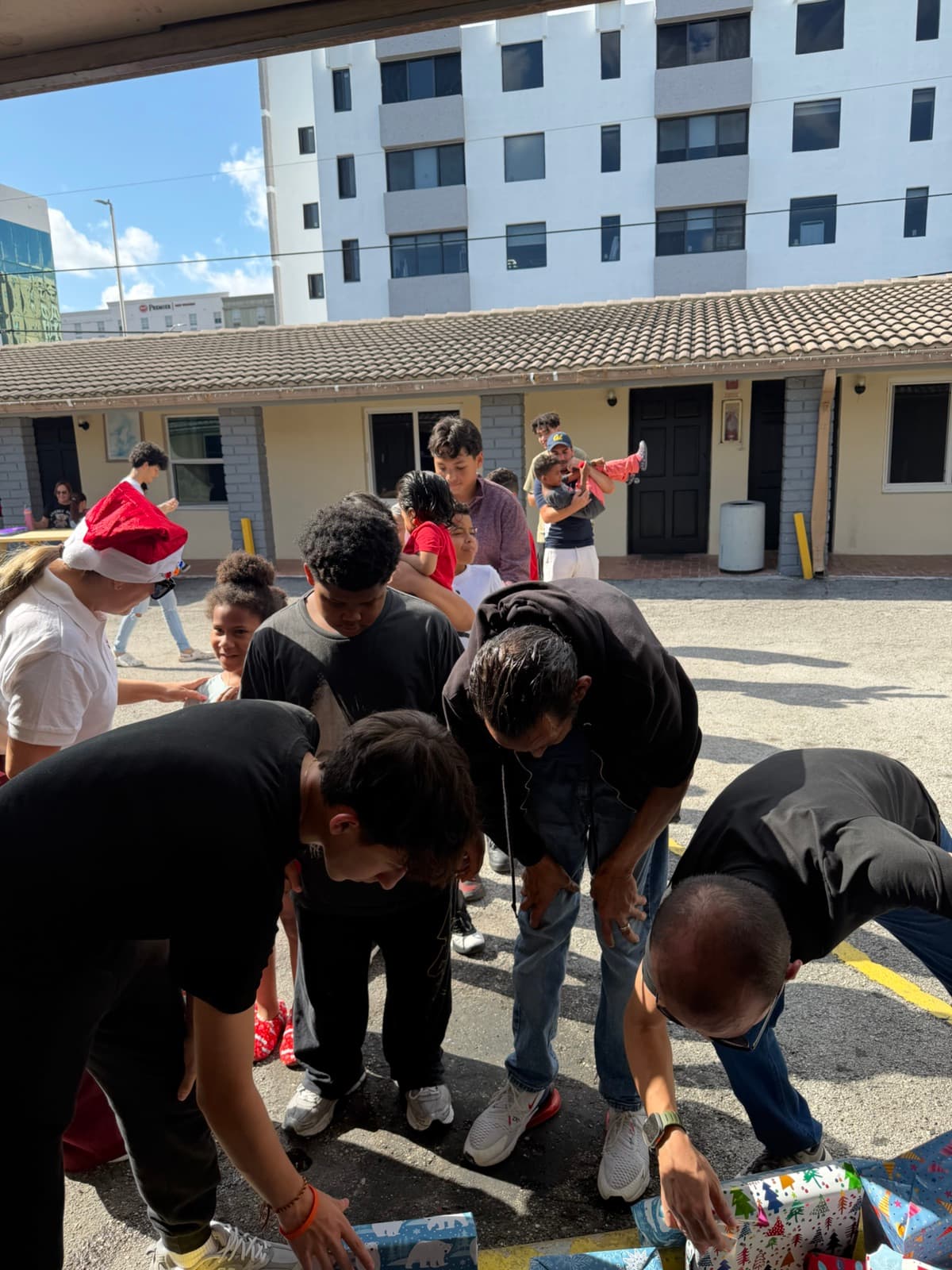 Volunteers handing out wrapped gifts to children at a Miami community event